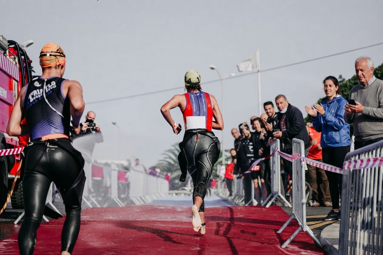 Sortie de nage en combinaison, sprint vers la zone de transition T1 avant de prendre le vélo
